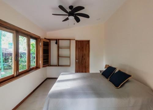 a bedroom with a large bed with a ceiling fan at Casa Jobo en Puerto Viejo in Hone Creek