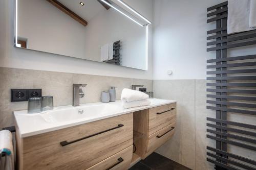 a bathroom with a sink and a mirror at Vitalhotel Sonnenhof in Going