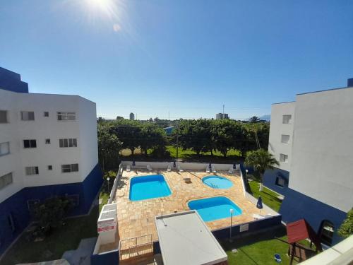 an overhead view of a swimming pool between two buildings at Apartamento com piscina à 1km da praia in Caraguatatuba