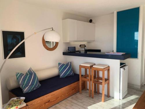 une petite cuisine avec un banc et deux tabourets dans l'établissement Résidence Port Nature Colline 5 - Port Nature Colline 5 - Appartement 4 personnes face Waiki MAE-6141, au Cap d'Agde