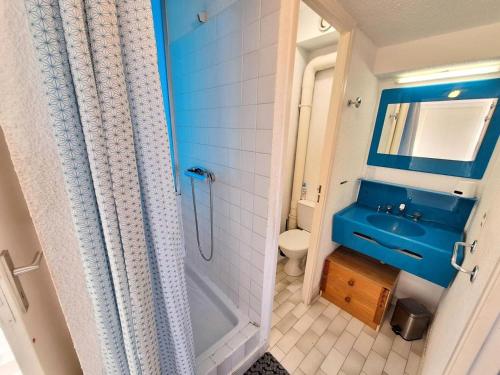 une salle de bain avec un lavabo bleu et une douche dans l'établissement Résidence Port Nature Colline 5 - Port Nature Colline 5 - Appartement 4 personnes face Waiki MAE-6141, au Cap d'Agde