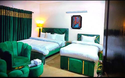 a hotel room with two beds and a chair at frank inn guest house in Islamabad