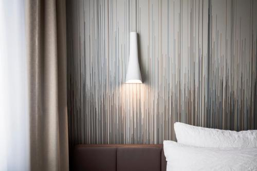 a room with a bed and a lamp on the wall at OKKO Hotels Cannes Centre in Cannes