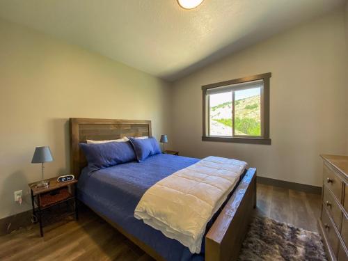 a bedroom with a bed and a window at Lake House Hill, Private Hot Tub, Lake Views in Garden City