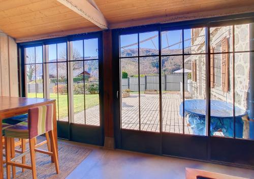 Cette chambre dispose de portes coulissantes en verre offrant une vue sur la terrasse. dans l'établissement Maison familiale en Auvergne, nature et confort, 20 min Lioran, à Vic-sur-Cère