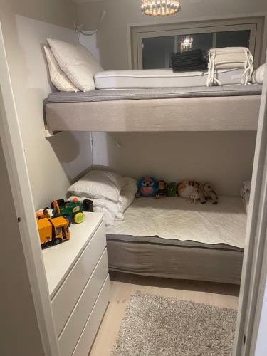 a room with two bunk beds with toys in it at Mysig stuga med sjöutsikt in Bergshamra