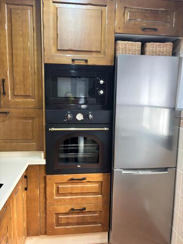 a kitchen with a stove and a refrigerator at Casa Azacanes in Sanlúcar de Barrameda