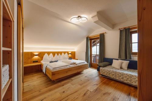 a hotel room with a bed and a couch at Bauernhof Unterbichl in Flachau