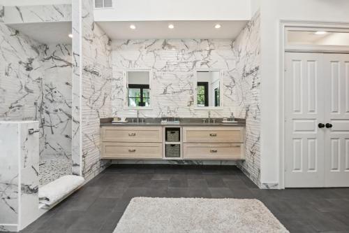 a bathroom with two sinks and a marble wall at Midtown 6bed 5bath w pool and sauna in Atlanta