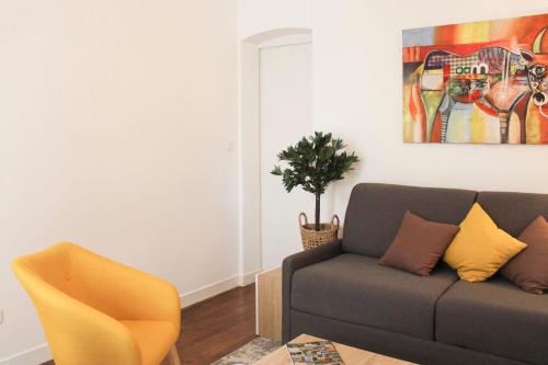 un salon avec un canapé et une plante dans l'établissement Elegant Parisian apartment in the heart of the 9, à Paris