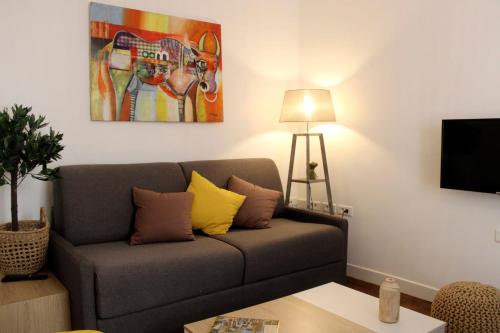 un salon avec un canapé et un tableau au mur dans l'établissement Elegant Parisian apartment in the heart of the 9, à Paris