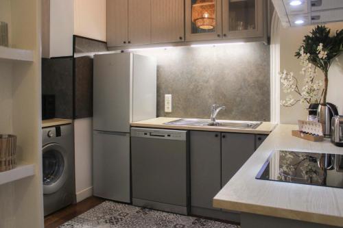 une cuisine avec un évier et une machine à laver dans l'établissement Elegant Parisian apartment in the heart of the 9, à Paris