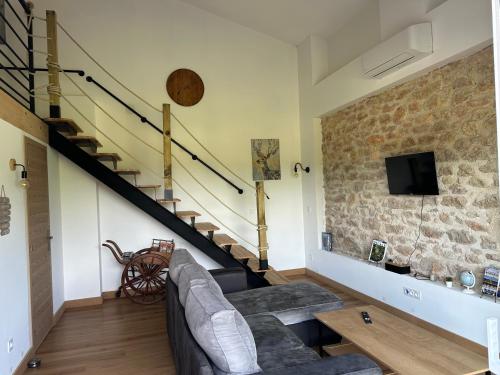 ein Wohnzimmer mit einer Couch und einer Treppe in der Unterkunft La Cabane de Nina, cottage chaleureux in Plassac