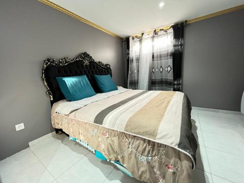 une chambre avec un grand lit avec des oreillers bleus dans l'établissement Appartement Epinay-Sur-Seine Près du stade de France, à Épinay-sur-Seine