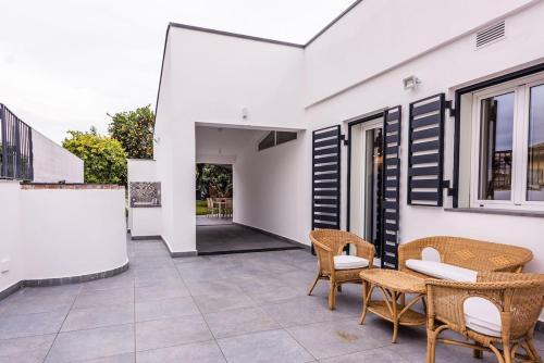 a patio with wicker chairs and a table at Oasi Agrumi e Mare in Mascali