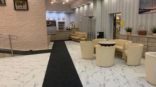 a lobby with a waiting area with tables and chairs at Laguna Resort SPA in Augustów