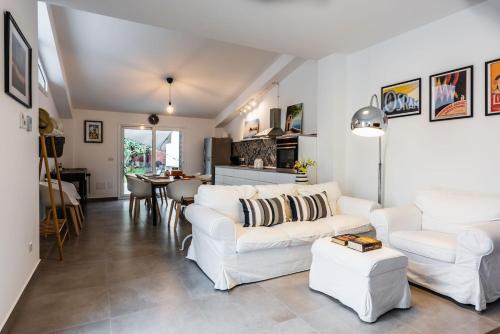 a living room with two white couches and a table at Oasi Agrumi e Mare in Mascali