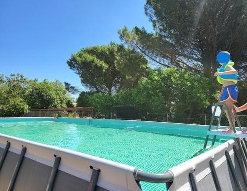 a couple of people standing on a chair near a swimming pool at Oasi Agrumi e Mare in Mascali