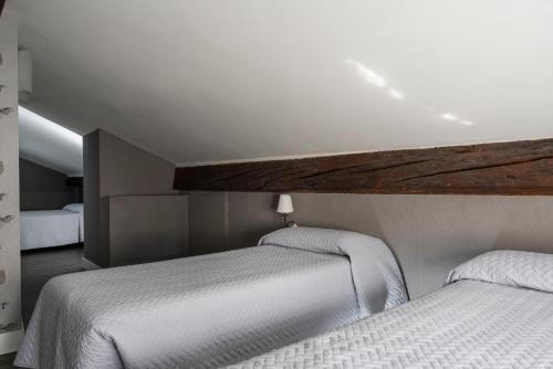 two twin beds in a room with at Maxxim Hotel & Loft in Ferrara
