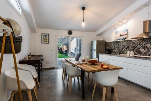 a kitchen with a wooden table and white cabinets at Oasi Agrumi e Mare in Mascali