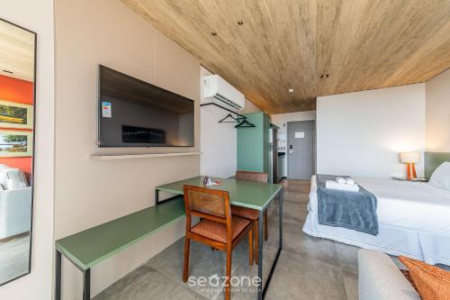 a bedroom with a bed and a desk and a tv at NWTs - Estúdios em Prédio com Vista Mar in Maceió