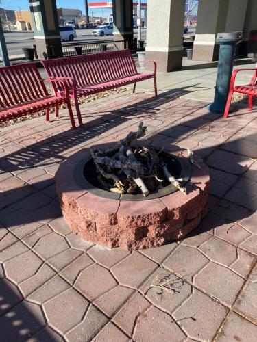 a fire pit in the middle of a sidewalk with two benches at Sonesta Essential - Rapid City in Rapid City