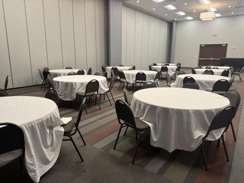 a room with tables and chairs with white table cloth at Sonesta Essential - Rapid City in Rapid City