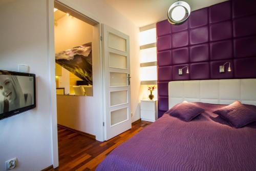 a purple bedroom with a bed and a tv at Katmandu in Zakopane