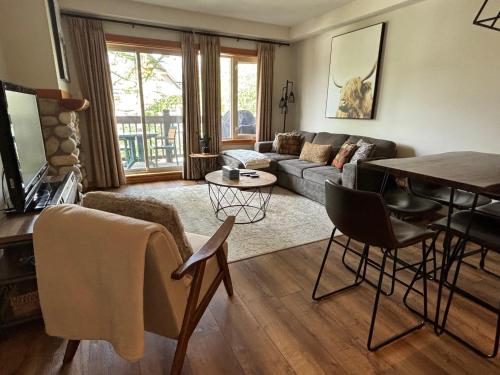 a living room with a couch and a table at Alpine at The Lodges of Canmore in Canmore