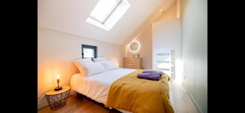 une chambre avec un lit et une lucarne dans l'établissement Gîte La Troglo, à Varrains
