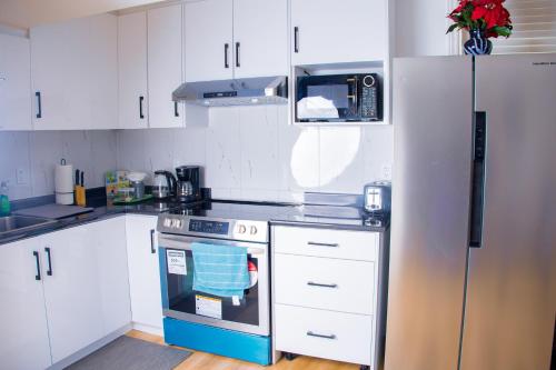 a kitchen with white cabinets and a blue oven at Cozy Haven 2 bedroom Basement apartment with Treated water in London