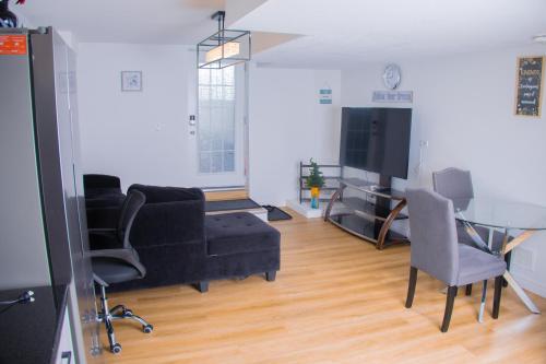 a living room with a black couch and a table at Cozy Haven 2 bedroom Basement apartment with Treated water in London