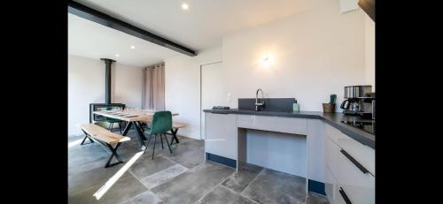 une cuisine et une salle à manger avec une table et des chaises dans l'établissement Gîte La Troglo, à Varrains
