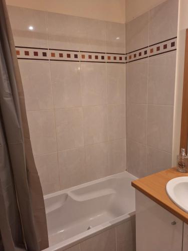 a bathroom with a bath tub and a sink at Victor Hugo - Hyper centre 2 chambres in Saintes