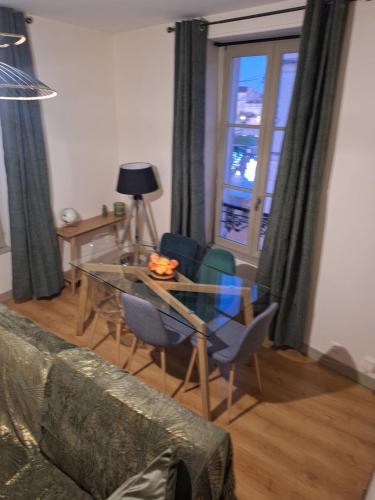 a living room with a glass table and chairs at Victor Hugo - Hyper centre 2 chambres in Saintes