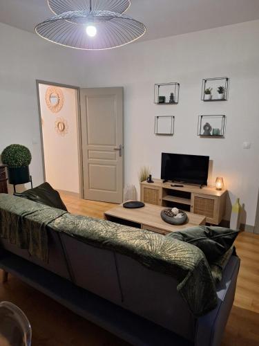 a living room with a couch and a flat screen tv at Victor Hugo - Hyper centre 2 chambres in Saintes
