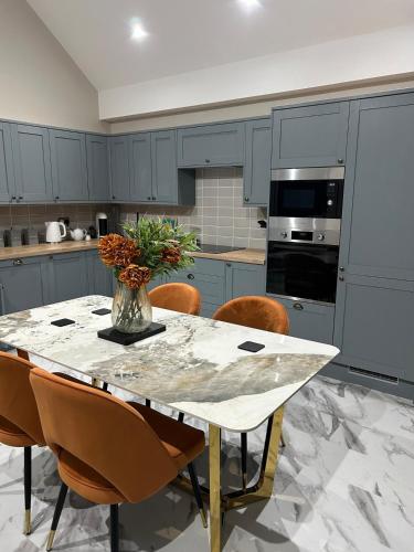 a kitchen with a table with a vase of flowers on it at The Cleveland Retreat - sauna stay in Boosbeck