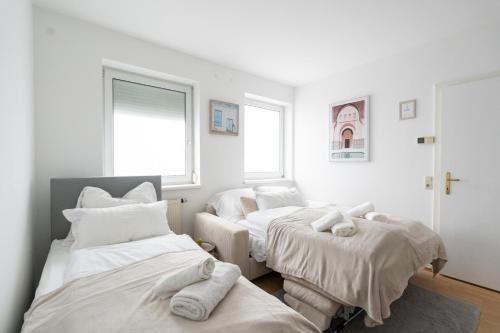 シュタイアーにあるSteyr Comfort Lodge Anytime Check In for Business and Familyのベッドが3つと窓が2つある部屋