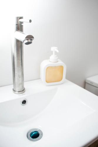 a bathroom sink with a soap dispenser on it at Zenia 70 Living & Suites in Medellín