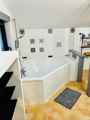 La salle de bains est pourvue d'une baignoire blanche et de carrelage. dans l'établissement La baudinière, à Artannes-sur-Indre