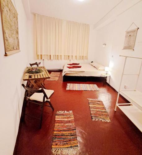 a room with a bed and a table and rugs at Studio Piata Amzei in Bucharest
