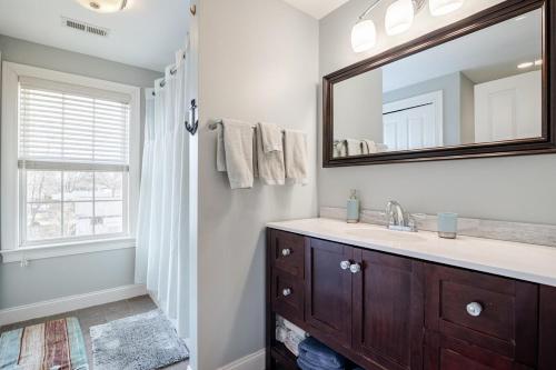a bathroom with a sink and a mirror at Seaside Solstice HOT TUB, SAUNA 4 Bedroom in Scituate