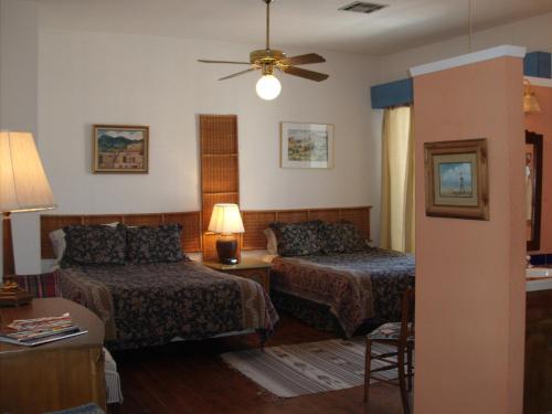 
a bedroom with two beds and a lamp at Lundeen Inn of the Arts in Las Cruces
