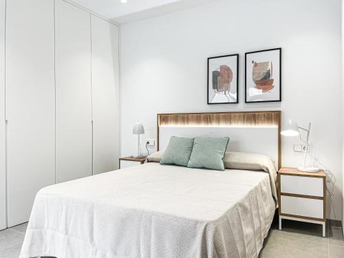 a white bedroom with a large bed and two lamps at Casa del Rayo de Sol in San Pedro del Pinatar