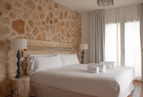 a bedroom with a white bed with towels on it at Hostal La Torre Ibiza Cap Negret in San Antonio