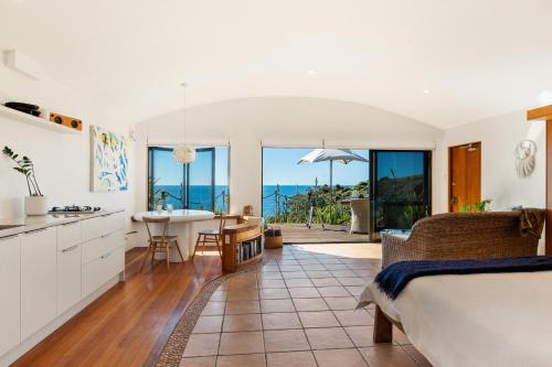 a kitchen and living room with a view of the ocean at Crab Cove in Mahinepua