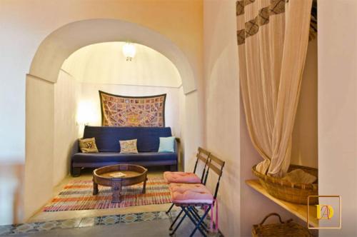 a living room with a blue couch and a table at Dammusi Ambra in Pantelleria