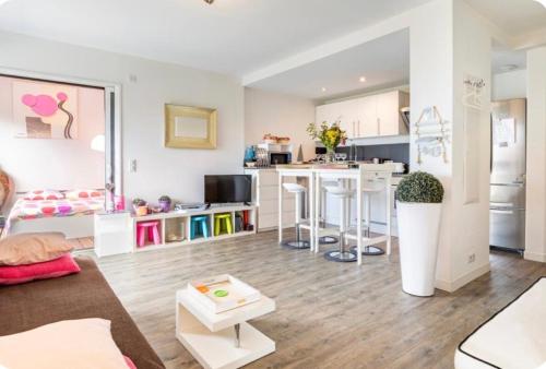 un salon avec un canapé et une cuisine dans l'établissement Le Neptune, à Contis-les-Bains