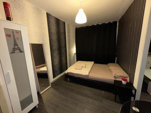 une petite chambre avec un lit et une table dans l'établissement Appartement Centre ville, à Mulhouse