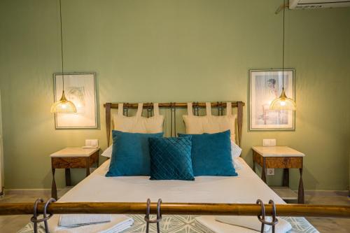 a bedroom with a large bed with blue pillows at Villa Mediterranean Oasis in Atsipopoulo